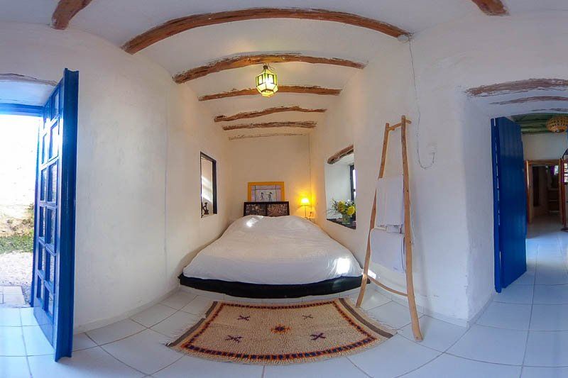 Une chambre aux portes bleues, lit double et tapis berbère