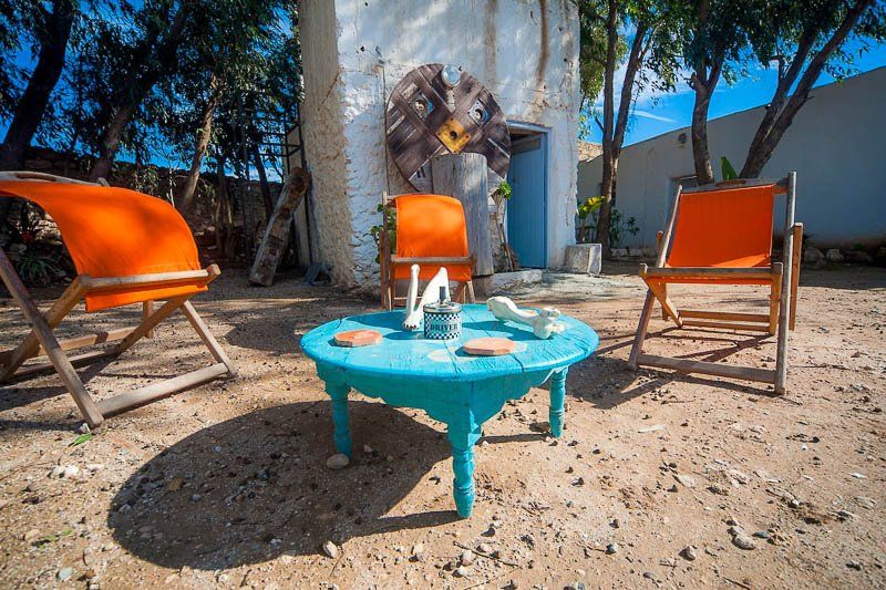 Le jardin, sa table basse turquoise et ses chaises orange