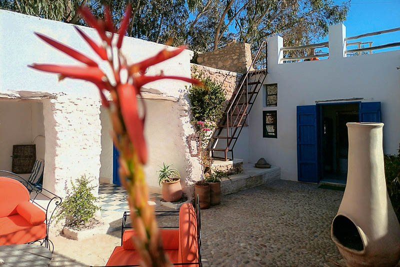 Le patio fleuri, son escalier et sa porte bleue